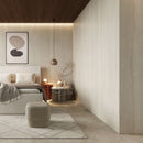 Modern bedroom with walls clad in Idevo SPC Wall Panels in Mineral Sand Color. Products in neutral tones, a bed, an ottoman, and wall art. Idevo wall panels are a great product for new construction and renovation projects